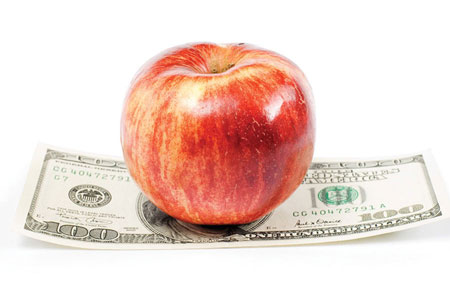An apple sitting on top of a One Hundred Dollar Bill